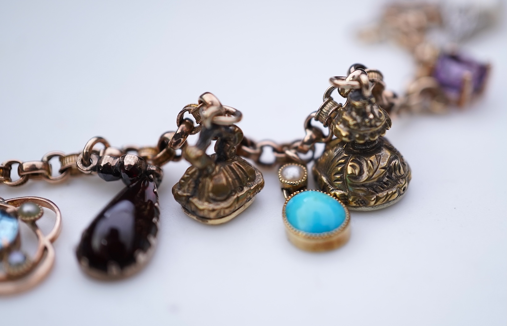 A gem-set charm bracelet, late 19th-early 20th century